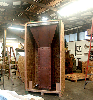 The oversized hood being carefully packed into it custom shipping box.